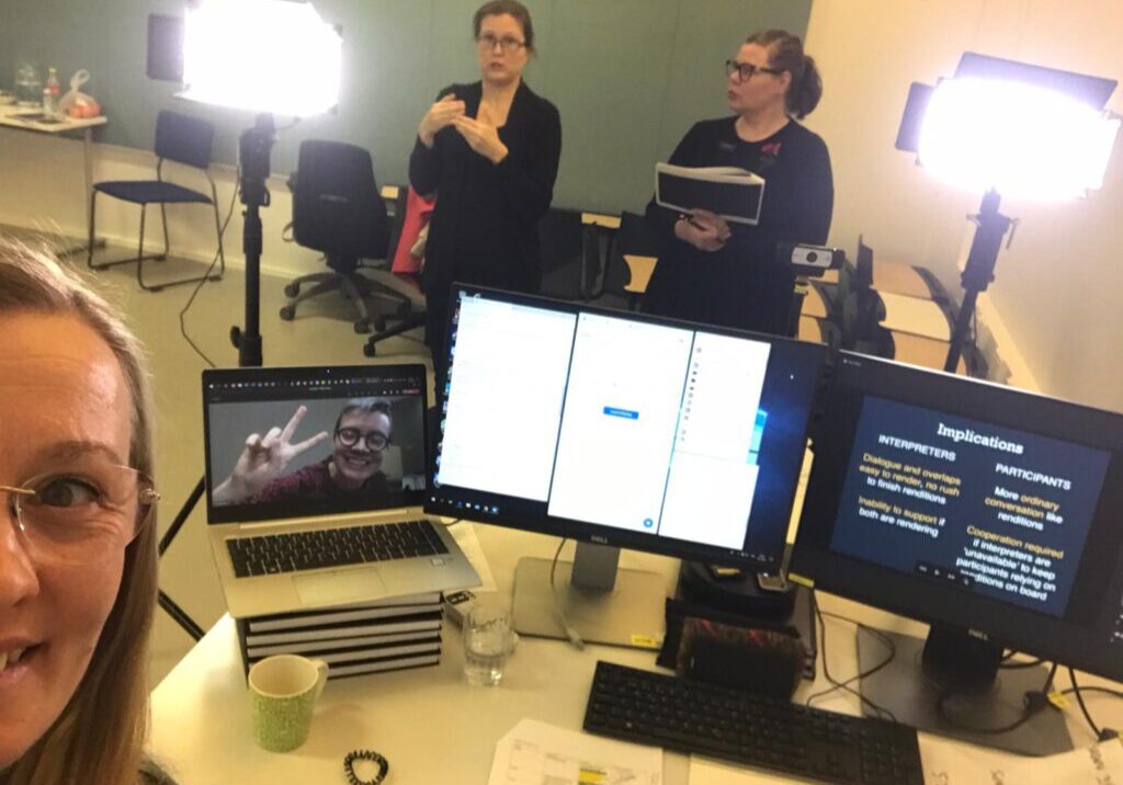 Verkkoseminaarin studiojärjestelyt ovat monipuoliset. Näyttöjä ja ihmisiä on monia.