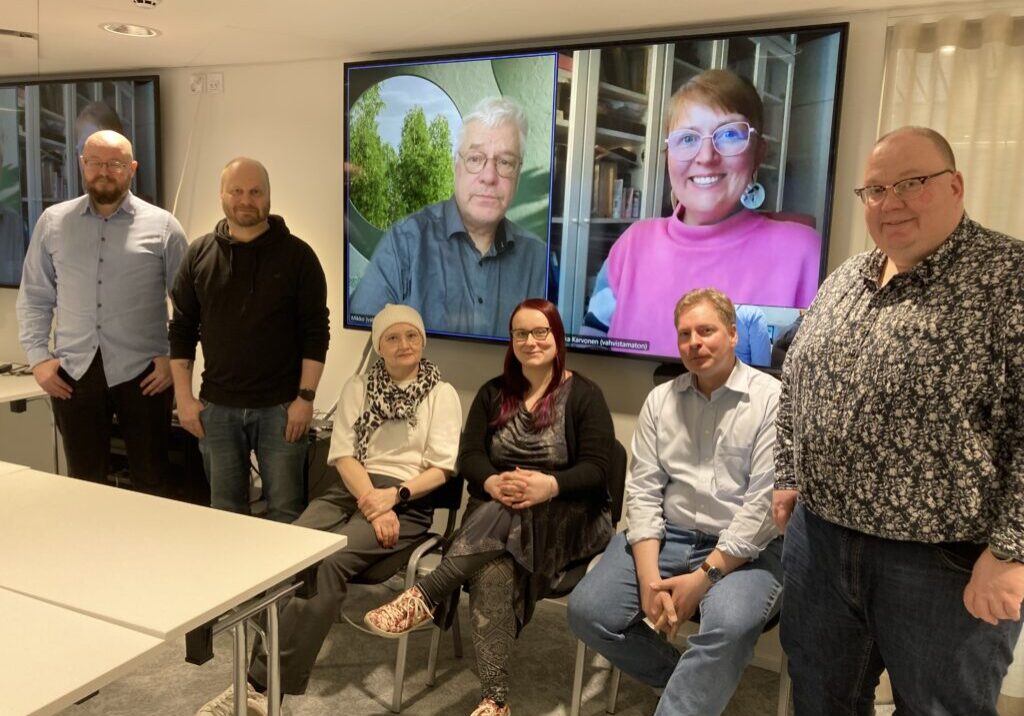 Av-käännösalan neuvottelijat yhteiskuvassa. Vasemmalta Jukka Sorsa, Janne Kauppila, Hanna Gorschelnik, Marketta Hakkarainen, Jaakko Sauvola ja Petri Savolainen sekä etäyhteydellä neuvotteluun osallistuneet Mikko Lyytikäinen ja Annika Karvonen. Kuva: Marja Honkonen, Journalistiliitto.